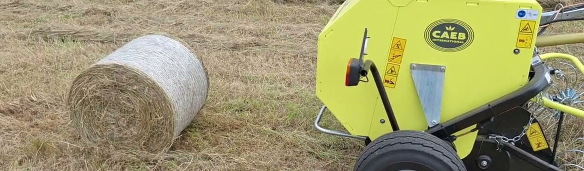 CAEB Mountainpress 550 TPL rundbalspress kopplad till traktor med pickup i hö
