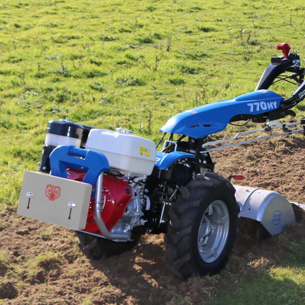 Tvåhjulstraktor i arbete utrustad med 15 kg frontvikt för bättre balans och kontroll.