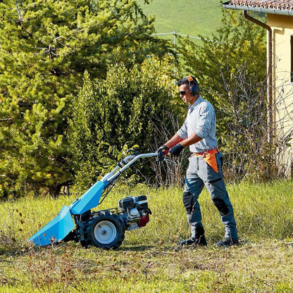 Lantbrukare använder Bertolini 150 SM slåttermaskin på kuperad terräng i trädgård