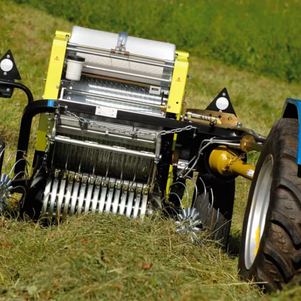 CAEB Mountainpress 550 TPL rundbalspress kopplad till traktor med pickup i hö