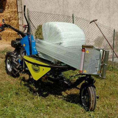 CAEB Mountainsilo monterad på tvåhjulstraktor som plastar in en höbal med balplast.