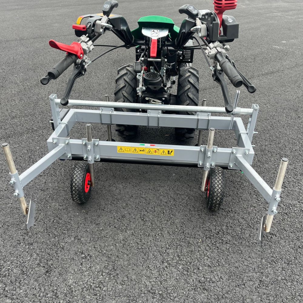 Bakbild av Ferrari plastläggare monterad på en kraftfull tvåhjulstraktor för professionell yrkesodling.