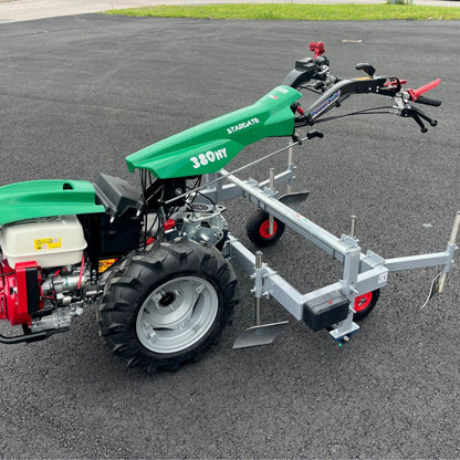 Frontvy av Ferrari plastläggare monterad på en kraftfull tvåhjulstraktor för professionell yrkesodling.