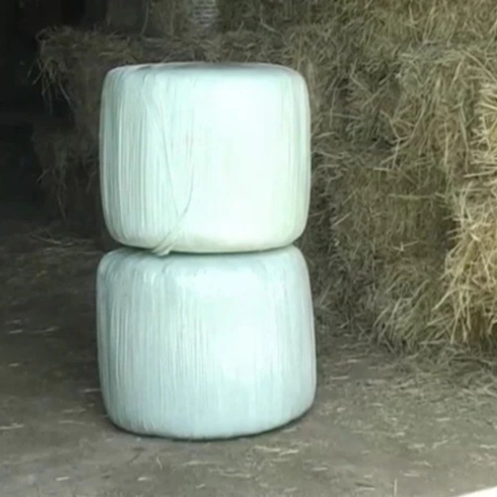 Två färdigplastade småbalar staplade i ett stall efter inplastning med CAEB Mountainsilo.