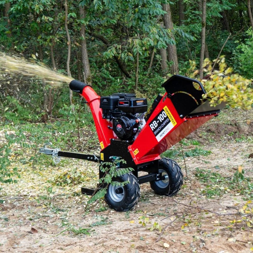 Bensindriven flishugg Remet RB-100 flisar grenar och blåser ut flis vid röjning i skogsmiljö.