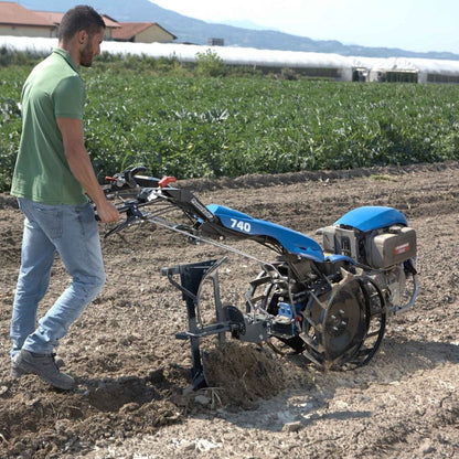 Plog i bruk som vänder jord och förbereder åkermark för odling.