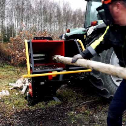 Remet RP-200 vedmaskin monterad bakom en traktor kapar stockar uop till 16 cm i diameter och tillverkar ved i längder upp till 30 cm