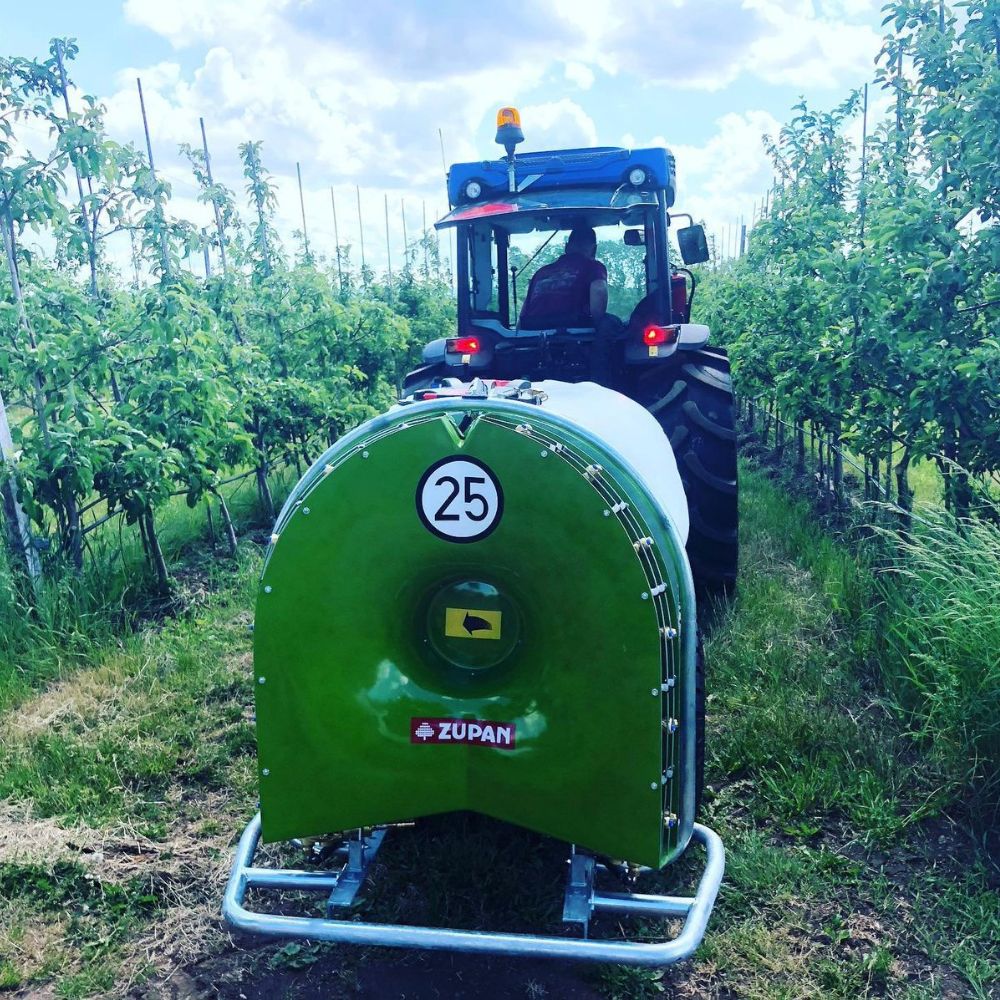 Bogserad fläktspruta 1500L Zupan monterad på traktor i fruktodling för växtskyddsbehandling